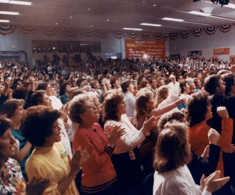 A group of associates cheer as Sam Walton receives the Presidential Medal of Freeedom.