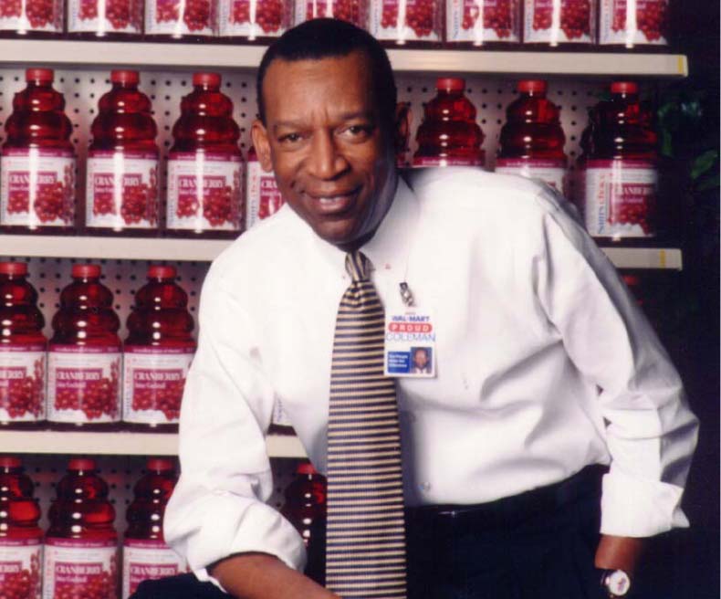 Walmart associate poses with cranberry juice at a Walmart Neighborhood Market.
