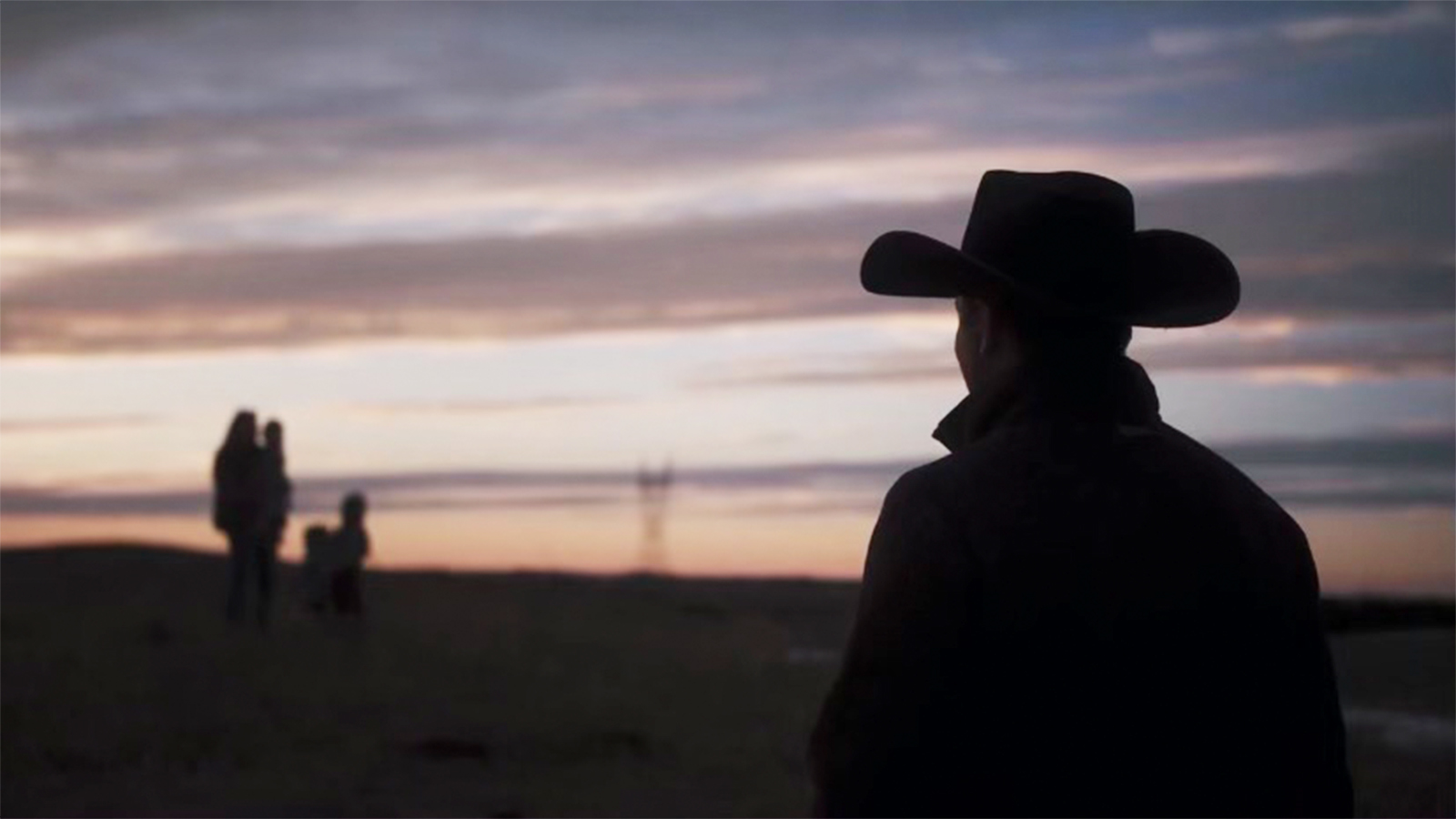 Person in Cowboy hat with sunset in background
