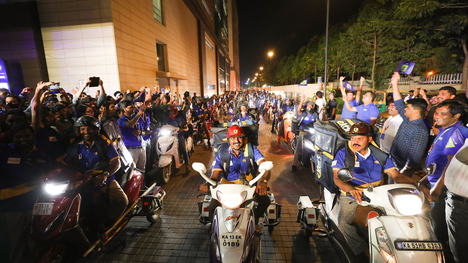 Indian Flipkart employees ride motorcycles in crowded street during Big Billion Days.