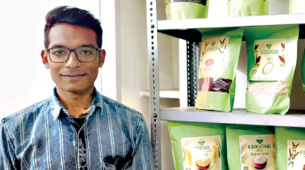 A close up image of Samir Padhan, Co-Founder, Danodia Foods, posing next to a shelf with his products.