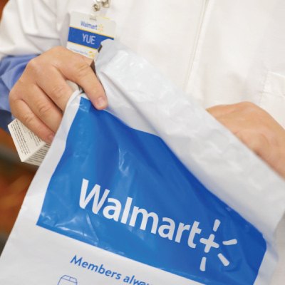A Walmart pharmacist places a prescription in a tamper-proof envelope.