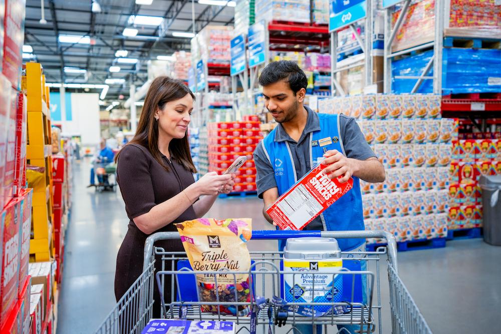 A Sam’s Club associate assists a member using her phone.