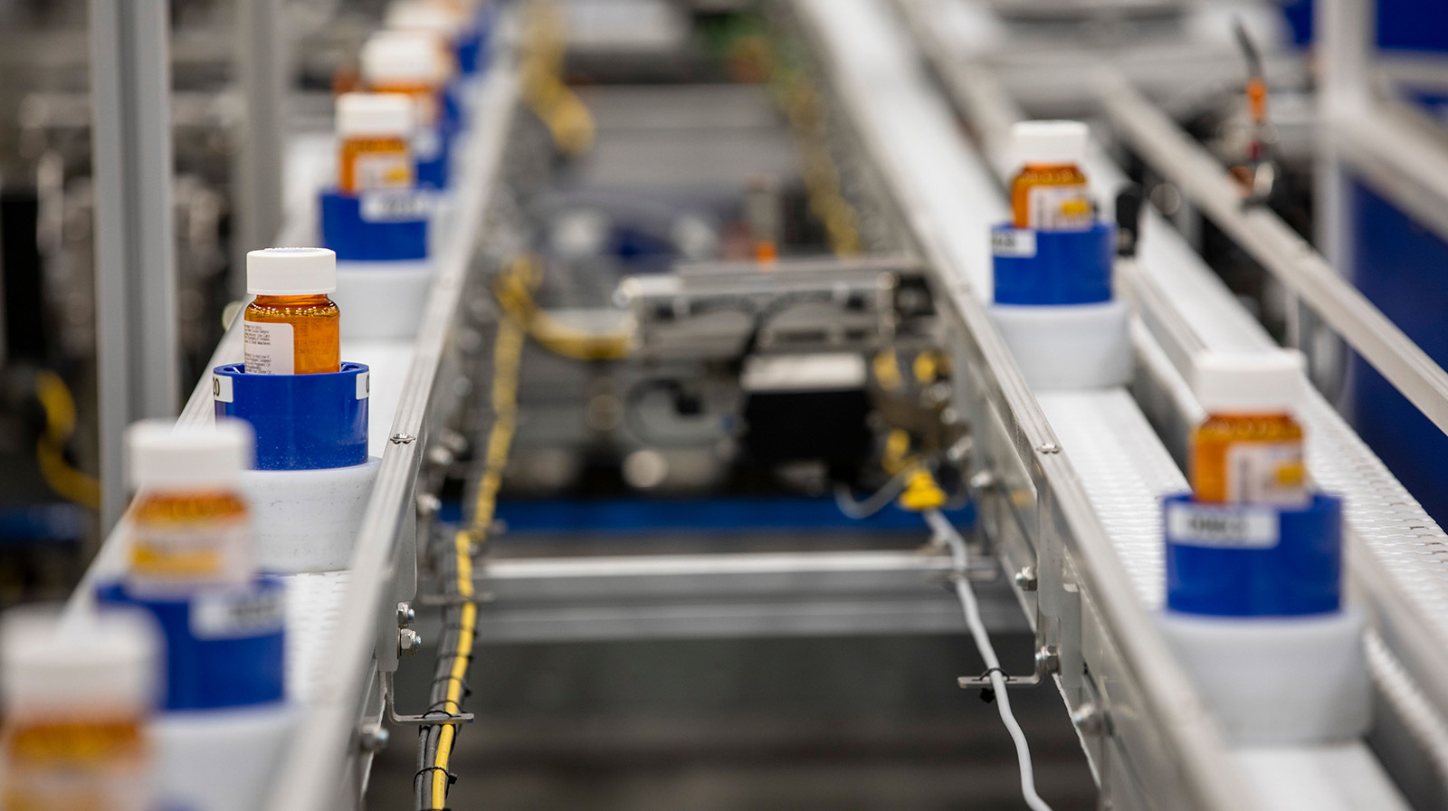 Prescription bottles on a conveyor belt in a Walmart Pharmacy Central Fill facility.