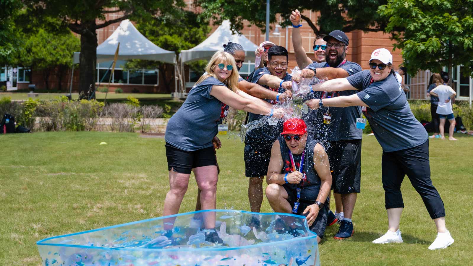 A group of Walmart associates pour water over the head of a colleague.