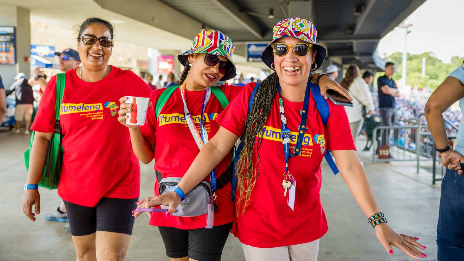 A group of three associates smile at the camera.