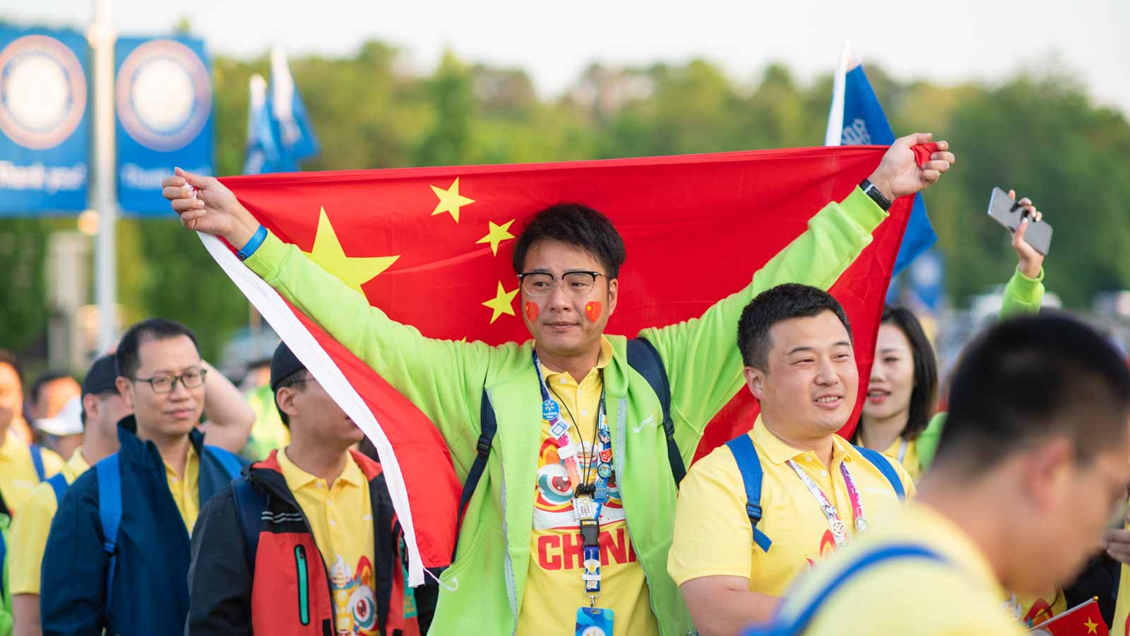 An associate from China holds the Chinese national flag behind his shoulders at Associate's Week.
