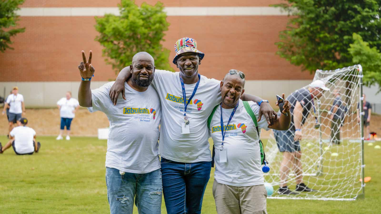 Three associates from Africa take a break from their soccer game to take a group photo.