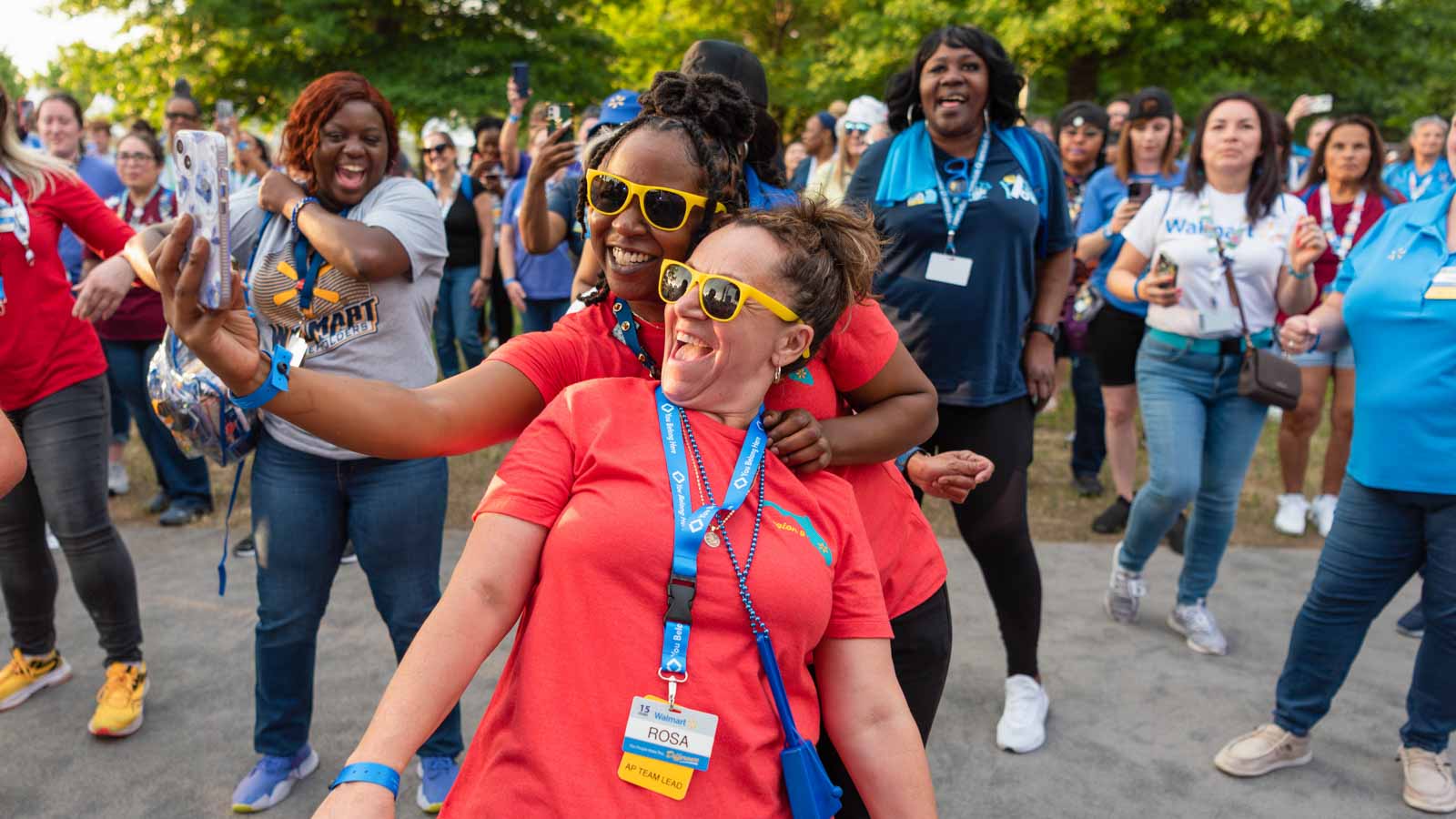 Associates take a selfie while friends look on from behind.