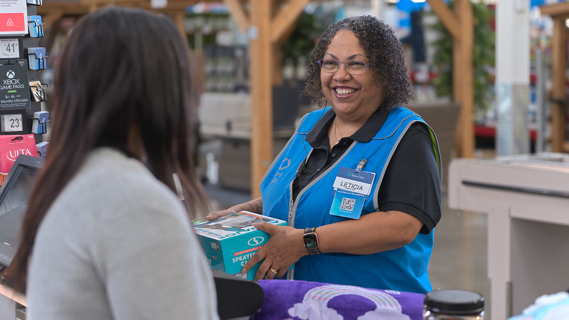 Sams associate scanning items at a register for a member