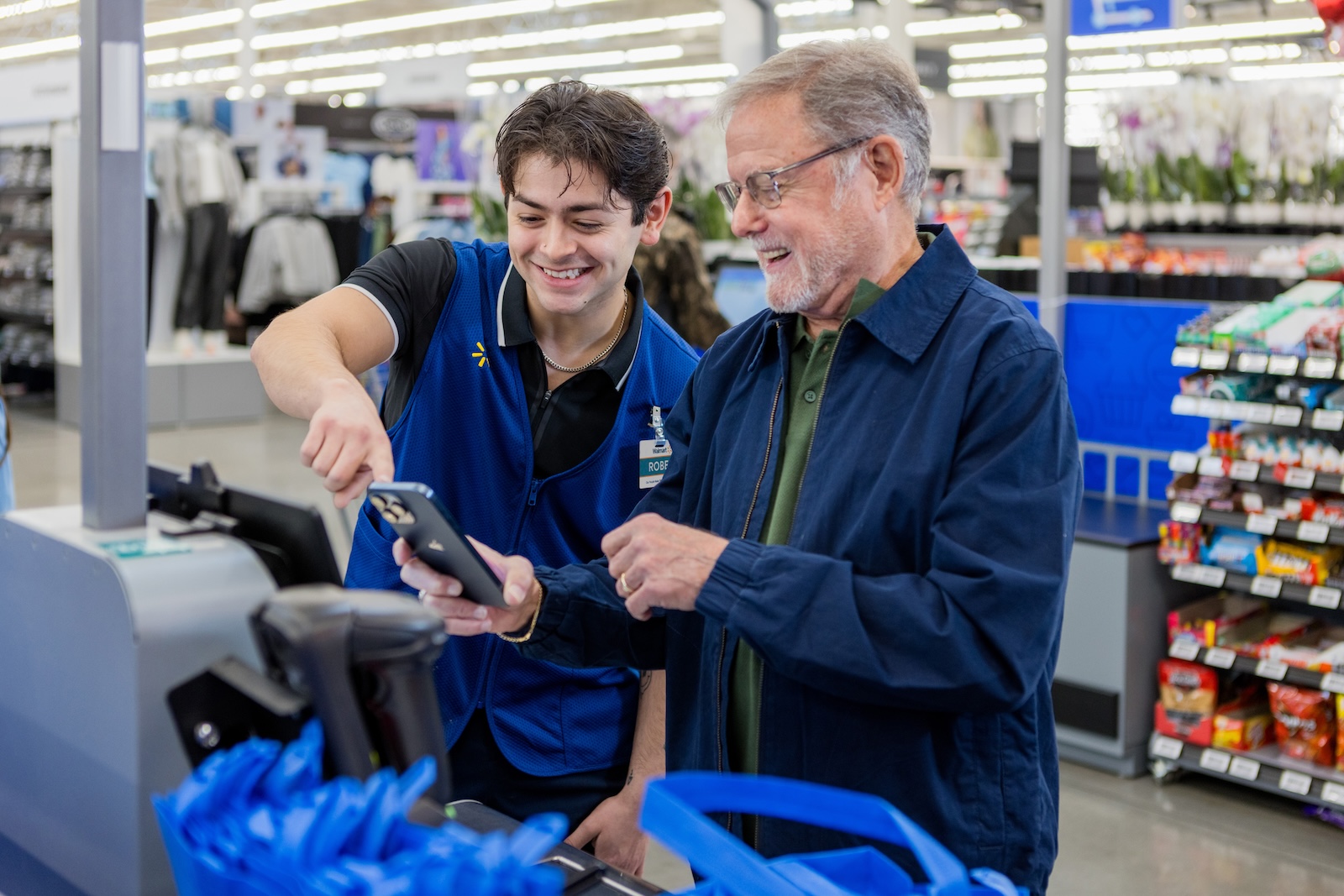 Walmart Associate smiling while helping a customer at a register.