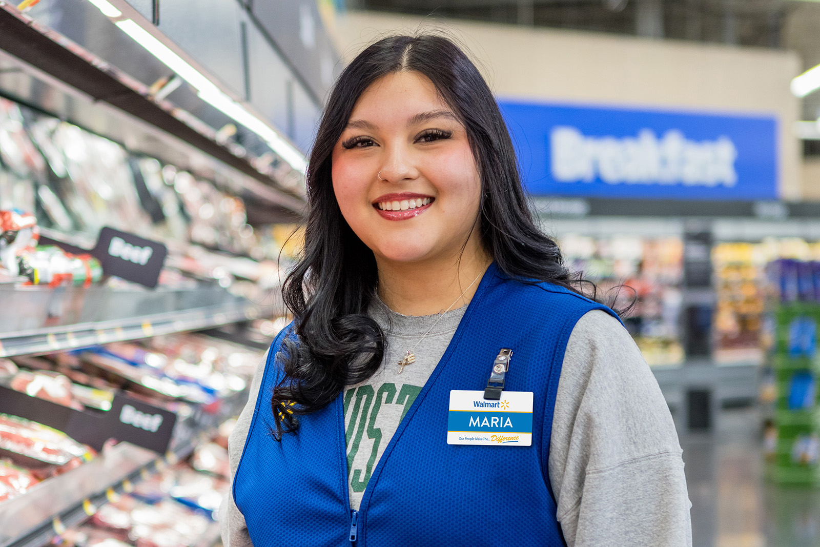 A Walmart LBU grad throws her graduation cap in the air in front of a Walmart store.