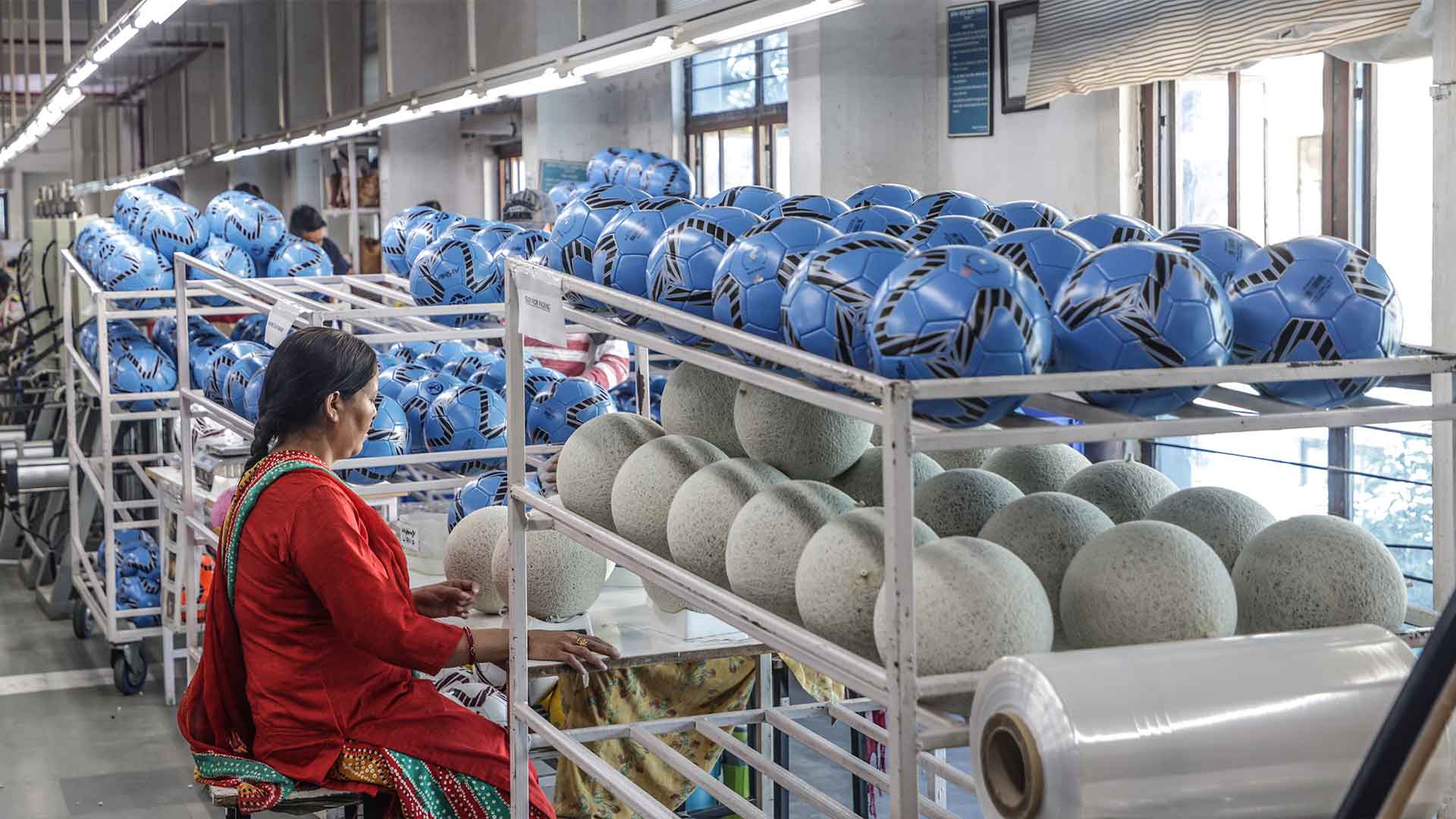 A woman works in a soccer ball factory in India
