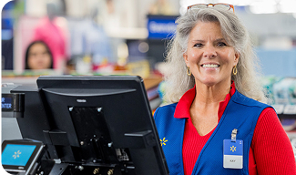 Photo of a Walmart associate working at a cash register smiling at the camera.